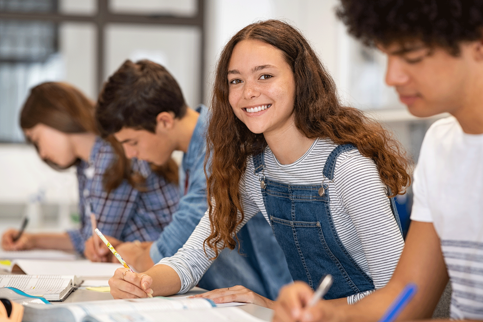 Grupo de estudiantes de secundaria caminando sonrientes por el pasillo de un instituto